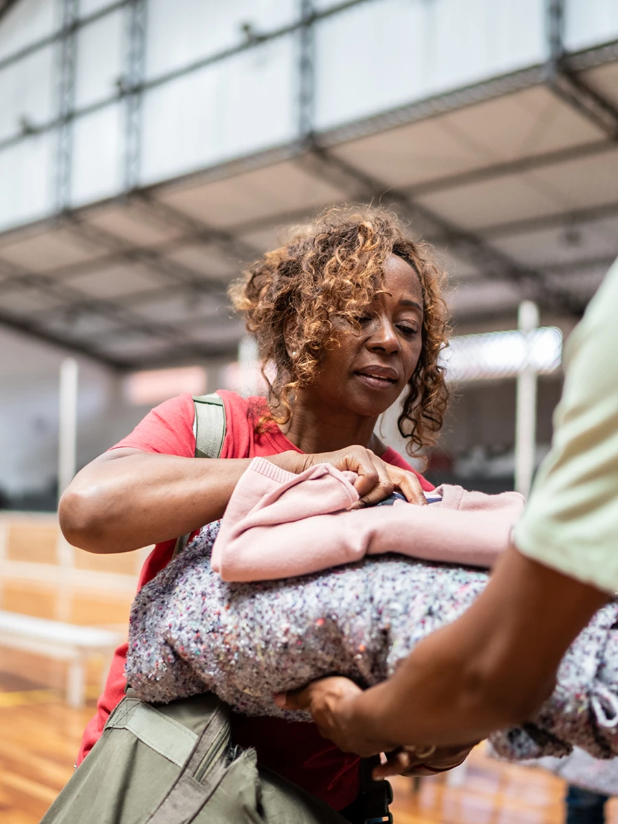 Woman handing over a bundle of clothes.